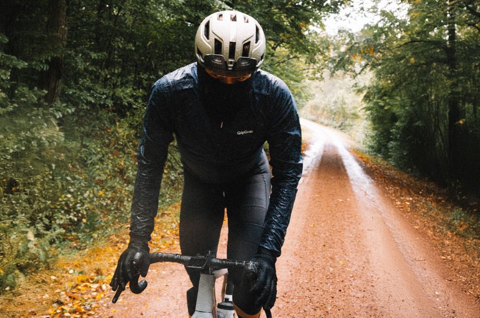 A cylist wearing GripGrap Apparel riding on a wet forest road