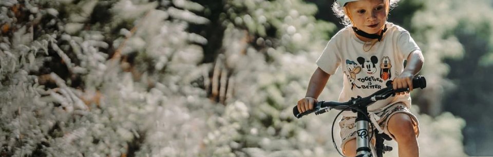 Bambino che pedala su una bici Early Rider