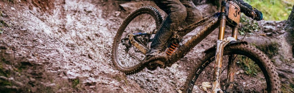 Bicicleta pintada con pintura Rotaris de larga duración manejando cuesta abajo en lodo.