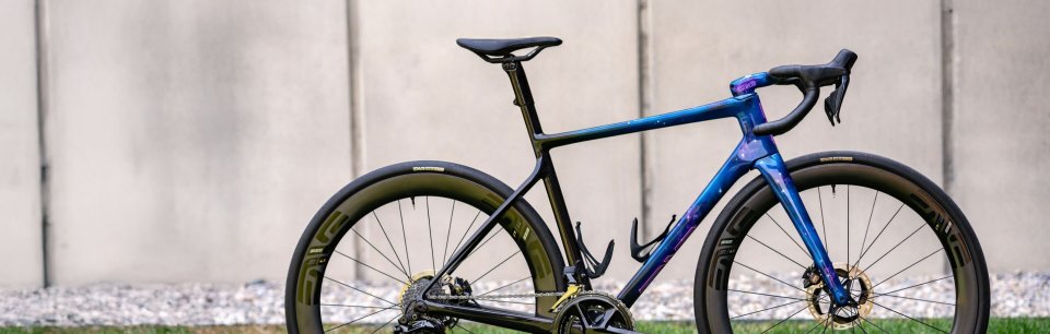 Un vélo route chic équipé d'une selle REFORM se tient devant un mur.