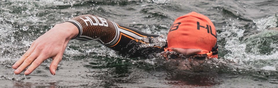 Atleta con una cuffia e una muta HUUB che nuota