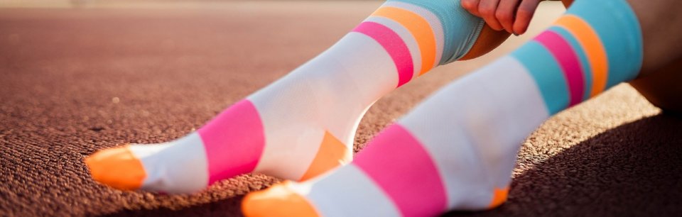Chaussettes INCYLENCE à rayures multicolores en gros plan sur un terrain de sport.