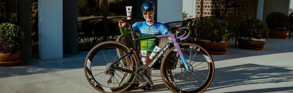Cyclist with a road bike holding SURPASS cream