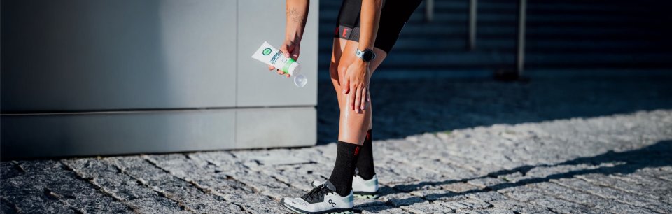 Persona che mette una crema sulle gambe dopo l'allenamento