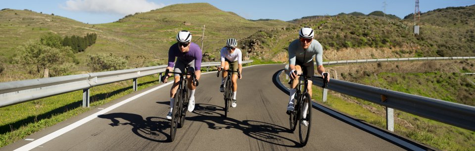 Radfahrer mit GripGrab Ausrüstung auf einer kurvigen Bergstraße unterstreichen Grip, Schutz und Leistung im Training.