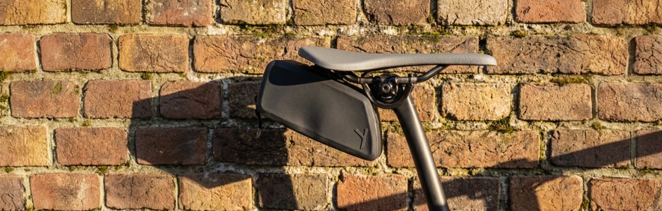 Ein Fahrrad mit Y-Mount Satteltaschenhalterung lehnt an einer Wand.